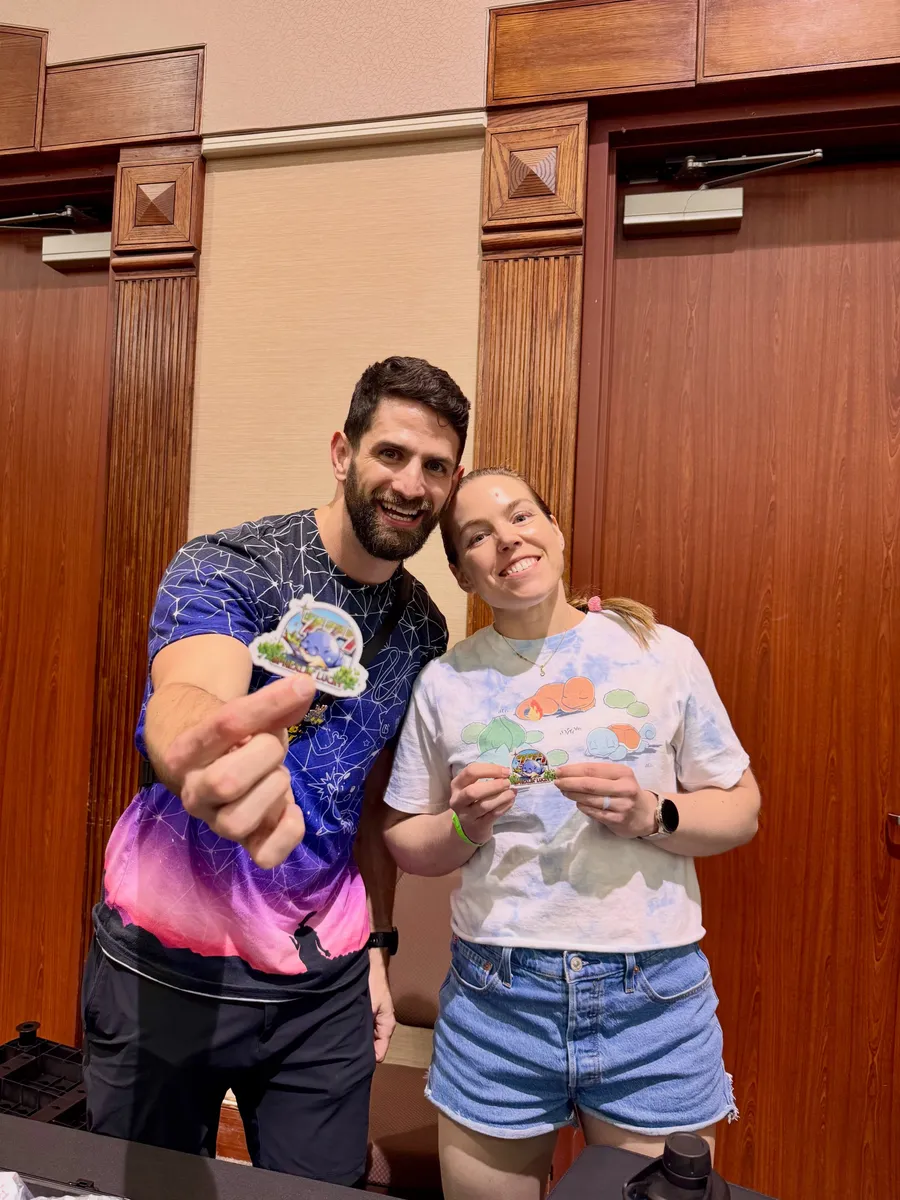 Two attendees showing off stickers from a vendor