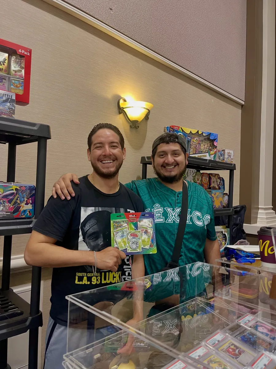 Two friends grinning with a sealed blister pack
