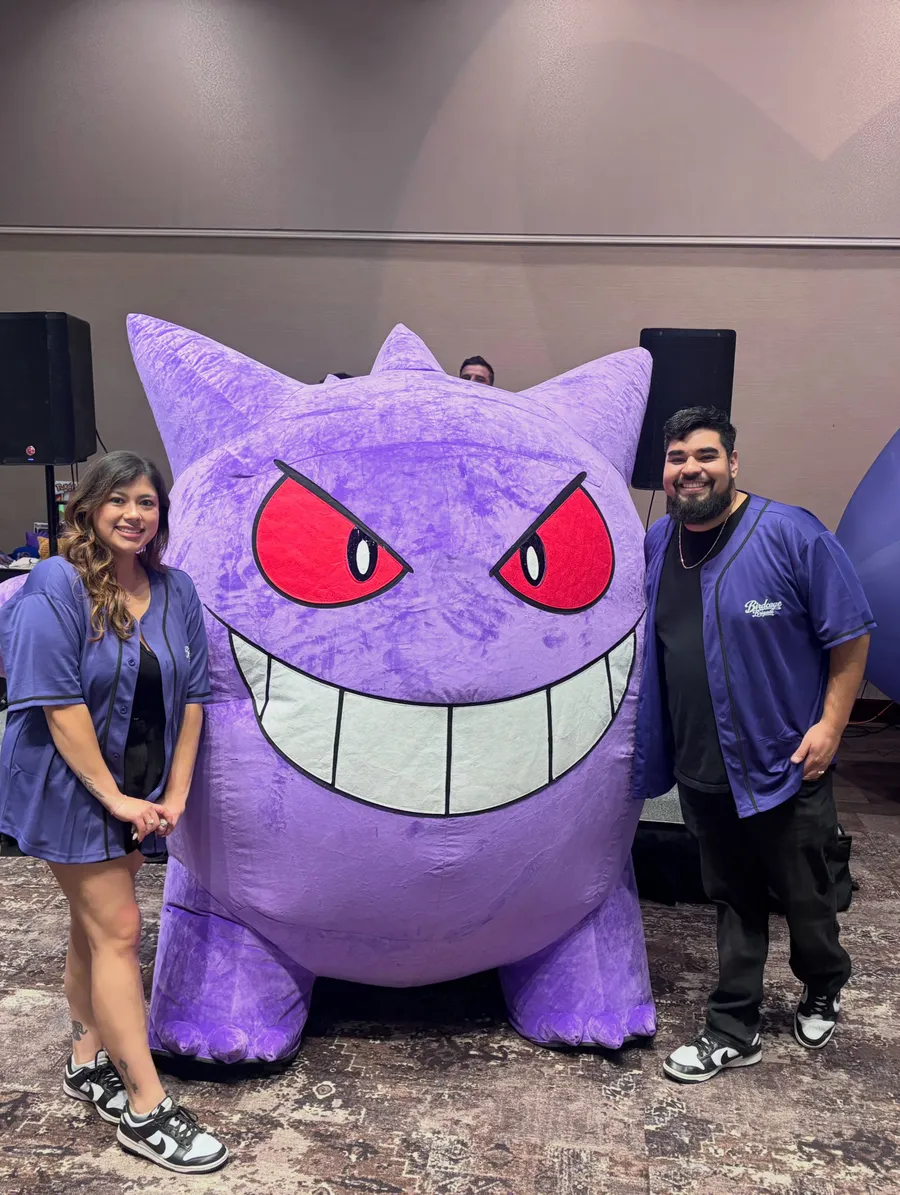 Two people posing with a giant inflatable Gengar