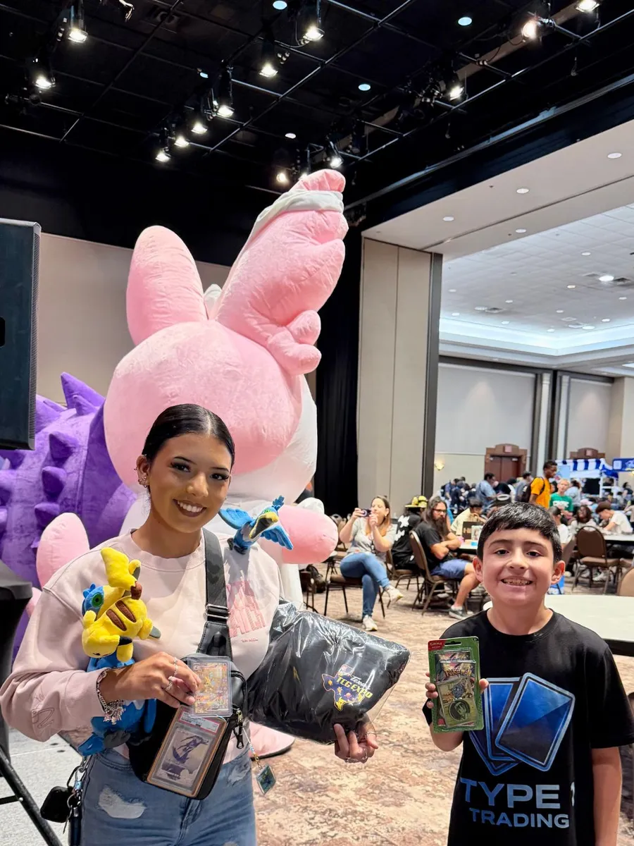 Two giveaway winners holding their prizes and a Texas TCG Expo bag