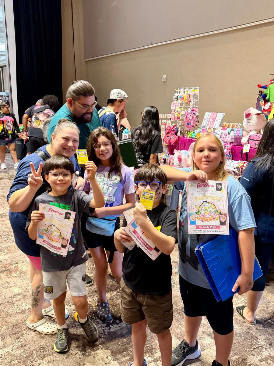 A group of kids showing off the cards and vouchers they got at the show