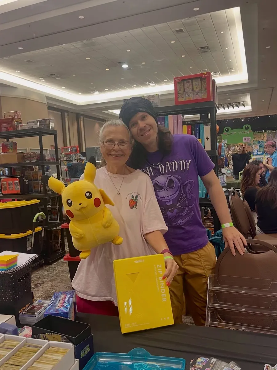 Two attendees with a Pikachu plush and a binder